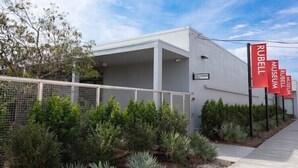 The exterior of the Rubell Museum with a modern architectural design, featuring a white facade and a clear sky. - Miami Health District • 2 Gbps Internet • 75” & 55” TVs • Stainless Steel (Miami)