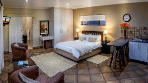 A bedroom with a bed, bedside tables, a desk, a chair, and a bathroom. - Room-guest Room With Double bed and Kitc (Gqeberha (Port Elizabeth))