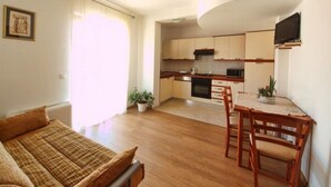 Un espace de vie compact comprenant une kitchenette, un coin repas et un canapé.