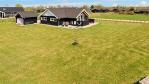 A residential area with houses, a large grassy field, and a clear sky. - 6 Person Holiday Home in Hadsund-by Traum (Hadsund)