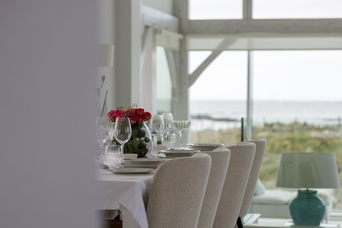 A dining table set for four with a view of the sea.