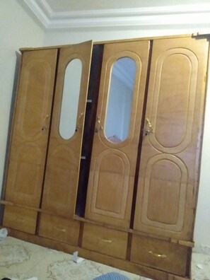 Simple, functional wardrobe with a central mirror and mirrored door.
