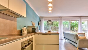 Eine moderne Küche mit weißen Schränken, einem eingebauten Backofen und einem großen Fenster.