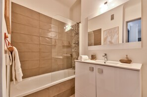Bathtub, hair dryer, towels, toilet paper