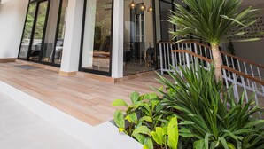 A modern building with a glass entrance, a wooden floor, and a staircase with a railing. - Palmetto Condominium (Karon)