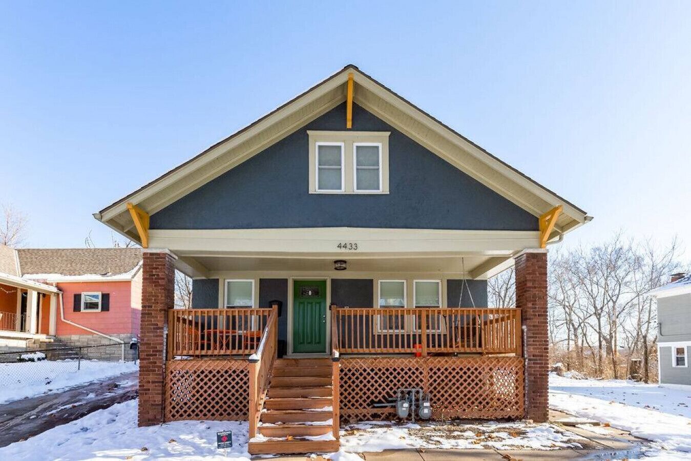A two-story house with a front porch, a green door, and a number 4433 on the front.