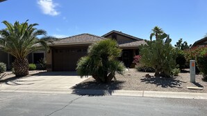 A residential house with a garage, palm trees, and cacti in the driveway. - Golfer's Paradise!!!-On Johnson Ranch Golf Course with pool! (San Tan Valley)