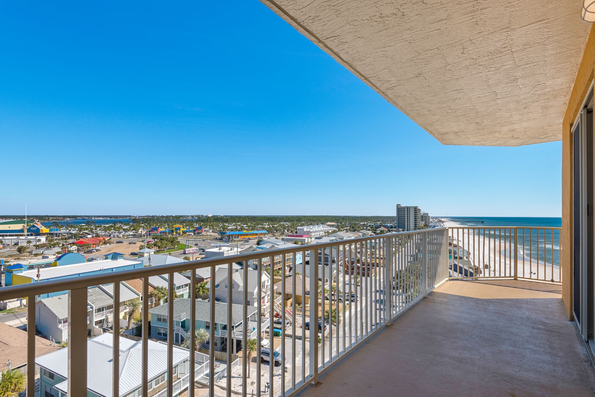Uma varanda com vista para uma praia e uma cidade.