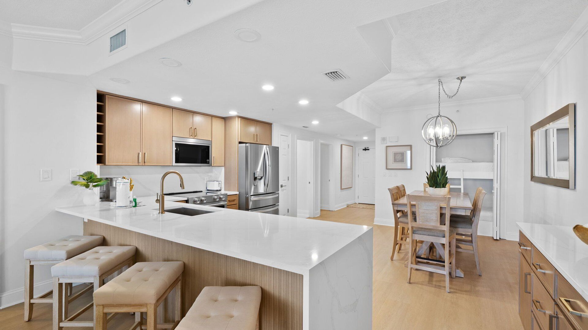 Una cocina moderna con una isla central, electrodomésticos de acero inoxidable y armarios de madera.