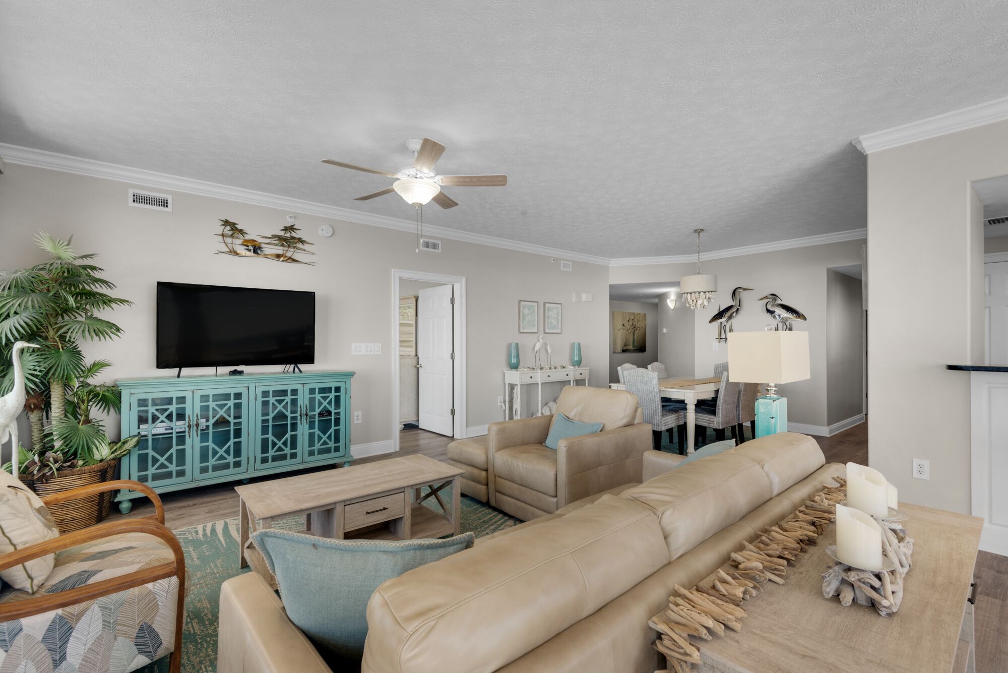 A living room with a television, sofa, and a dining area with chairs and a table.