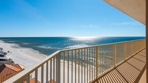 Un balcon avec vue sur une plage et l’océan.
