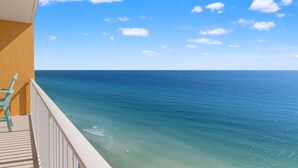 A balcony with a view of the ocean and a clear sky.