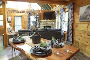Un tavolo da pranzo in legno apparecchiato con piatti, bicchieri e un vaso con piante.