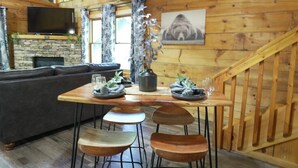 Un interior de madera con una mesa de comedor, sillas, un sofá, un televisor y una chimenea.