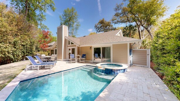 A modern house with a swimming pool, patio furniture, and a covered outdoor area. - Stunning Hilton Head Island Vacation Rental! (Hilton Head)