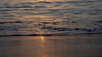 A sunset over a calm sea with gentle waves.