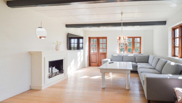 A spacious living room with a fireplace, a large sofa, and a dining table. - Amazing home in Søllested with WiFi (Søllested)