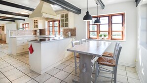 A spacious kitchen with a central island, white cabinetry, and a large window providing natural light. - Amazing home in Søllested with WiFi (Søllested)