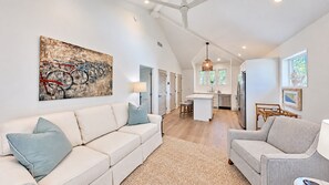 A spacious living area with a white sofa, a grey sofa, and a kitchen in the background. - Crystal Blue Persuasion - 1BR/1BA Blue Mountain Beach Carriage House - Sleeps 2 (Santa Rosa Beach)