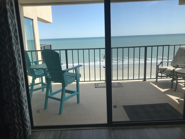 A balcony with a view of the ocean, two chairs, and a small table. - OCEAN BLISS! Beautiful oceanfront condo with large balcony and amazing views! (North Myrtle Beach)