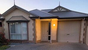A residential house with a brick facade, a garage door, and a paved driveway. - Our most popular home. Your family and staff will love it here! Bed & bath linen hire included. Unlimited NBN WIFI internet. Airconditioning throughout. Easy Parking. Spacious and relaxing. (Richmond)