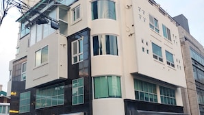 Ein mehrstöckiges Gebäude mit moderner Architektur, das große Fenster und ein Flachdach aufweist.