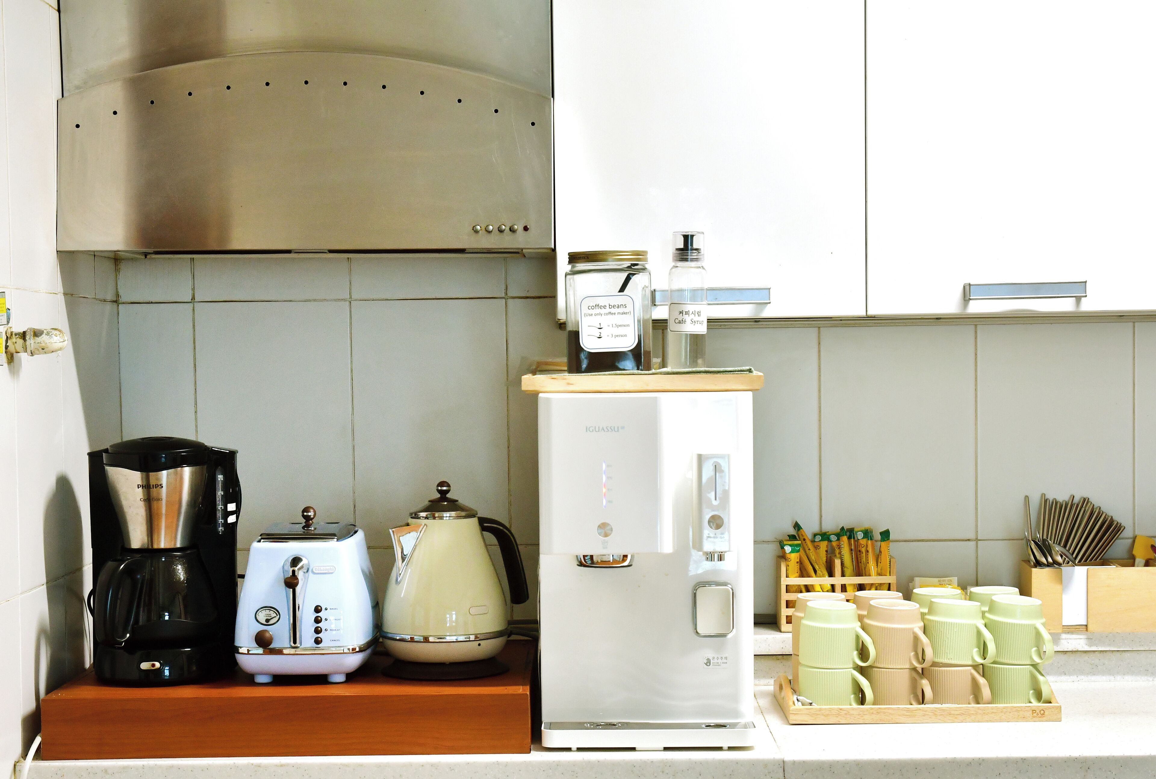 A kitchenette with a coffee maker, toaster, kettle, and a mini-fridge.