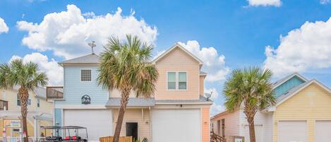 A two-story house with a garage, a satellite dish, and a golf cart parked in front.