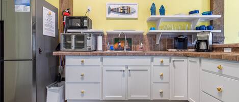 A compact kitchen with a refrigerator, microwave, and coffee maker.