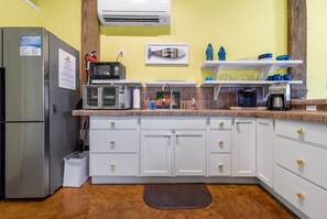 A compact kitchen with a refrigerator, microwave, and coffee maker. - Studio w/ Private hot tub after 10/11, no stairs (Port Aransas)
