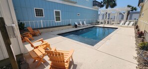 A swimming pool with lounge chairs and a pergola.