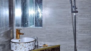 A bathroom with a round sink, a mirror, and a shower. - Bien Ngoc Ly Son Hotel (Ly Son)