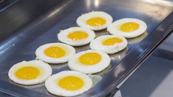 A stainless steel tray with six fried eggs.