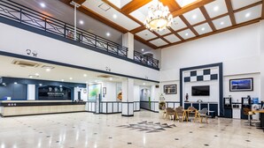 A spacious lobby with a reception desk, seating area, and a second-floor balcony. - Jeju Tovice Condo Ocean (Jeju City)