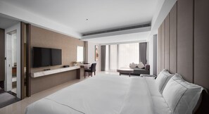 A modern hotel room with a large bed, a desk, and a TV. - Gamalan Spring Hotel (Jiaoxi)