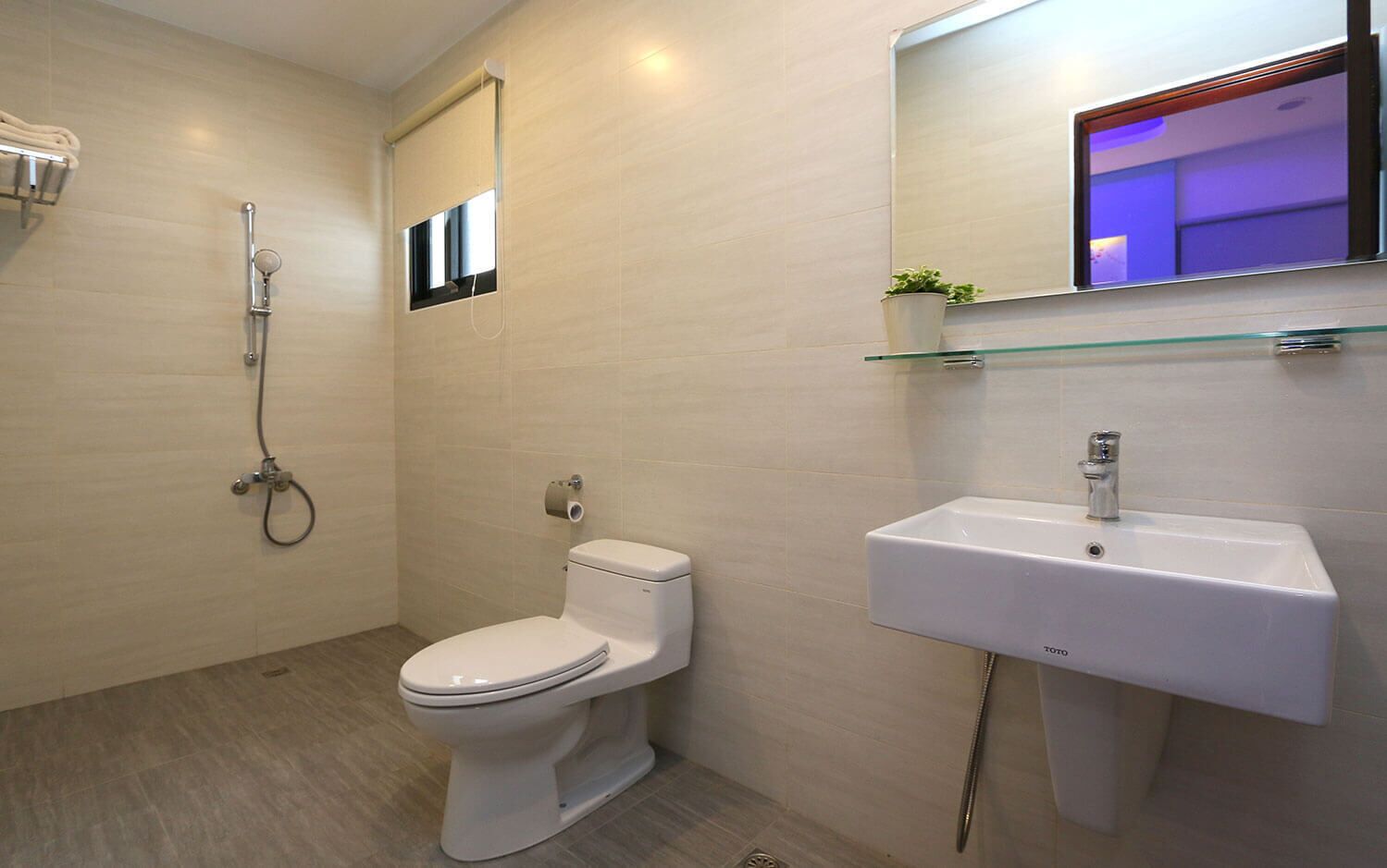 A modern bathroom with a toilet, a shower, and a sink.