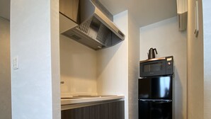 Een moderne keuken met een inbouwoven, magnetron en een zwarte koelkast.