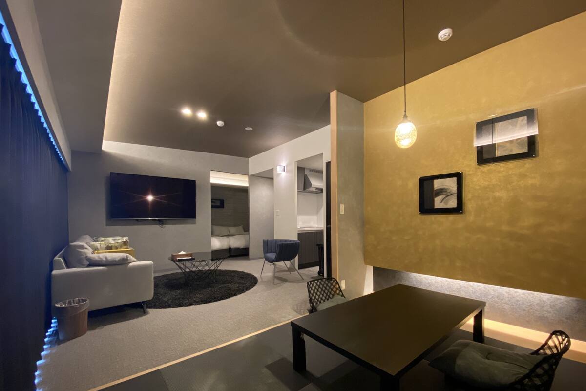 A modern living room with a sofa, a coffee table, and a TV mounted on the wall.