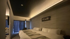 Een moderne hotelkamer met een groot bed, een bureau en een stoel.
