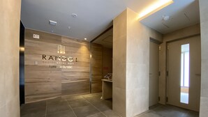 Een moderne hal met een houten wand waarop de naam 'RANDOR RESIDENTIAL HOT FUKUOKA CLASSIC' staat.
