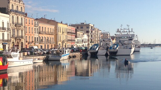 A marina with various boats docked along a waterfront, surrounded by historic buildings. - Charming 2-room apartment, city center, loggia, parking (Sète)