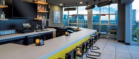 Un bar moderno con una barra alargada, taburetes y vistas a la ciudad a través de amplias ventanas.