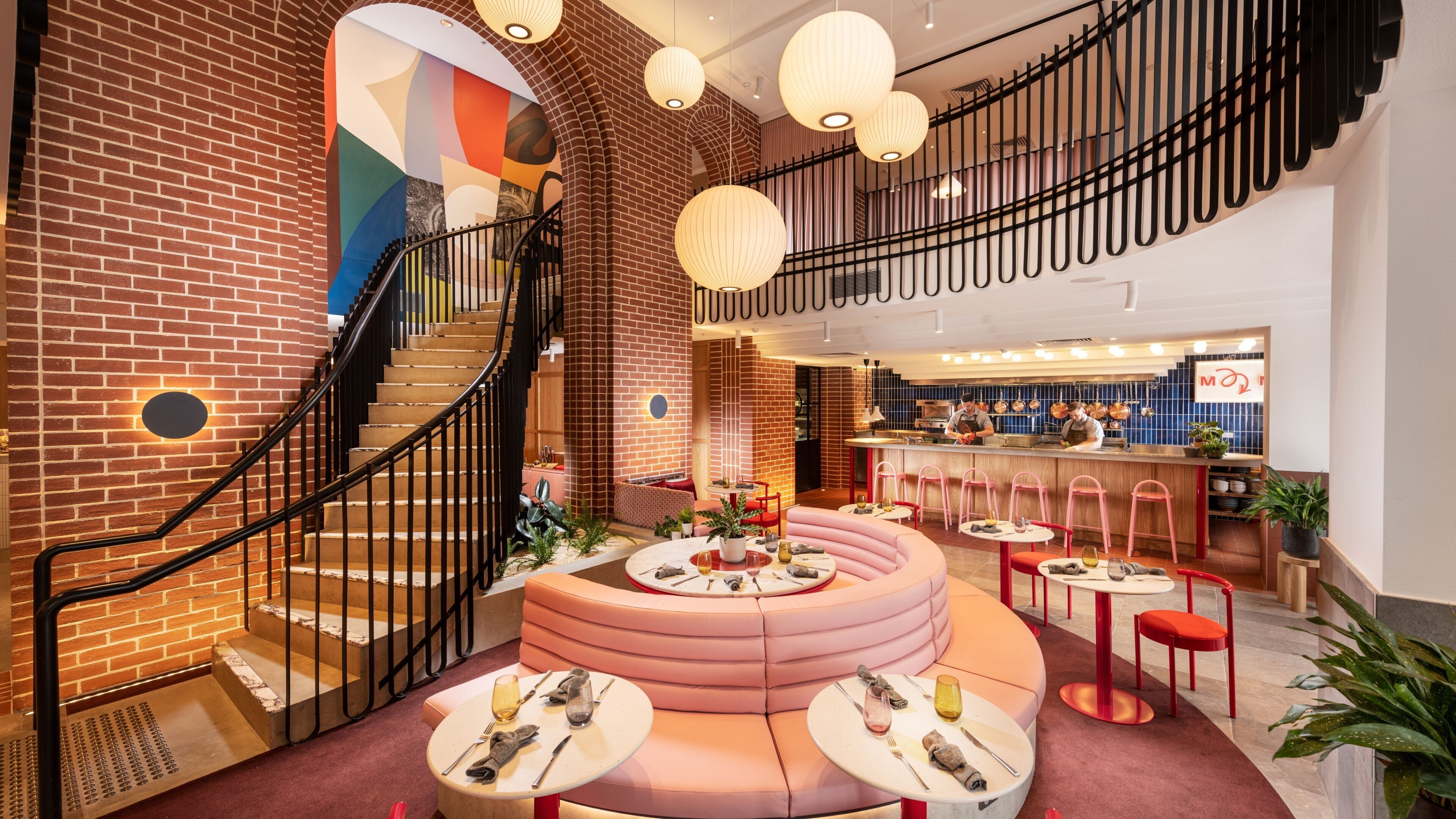A modern interior with a staircase, seating area, and a bar.