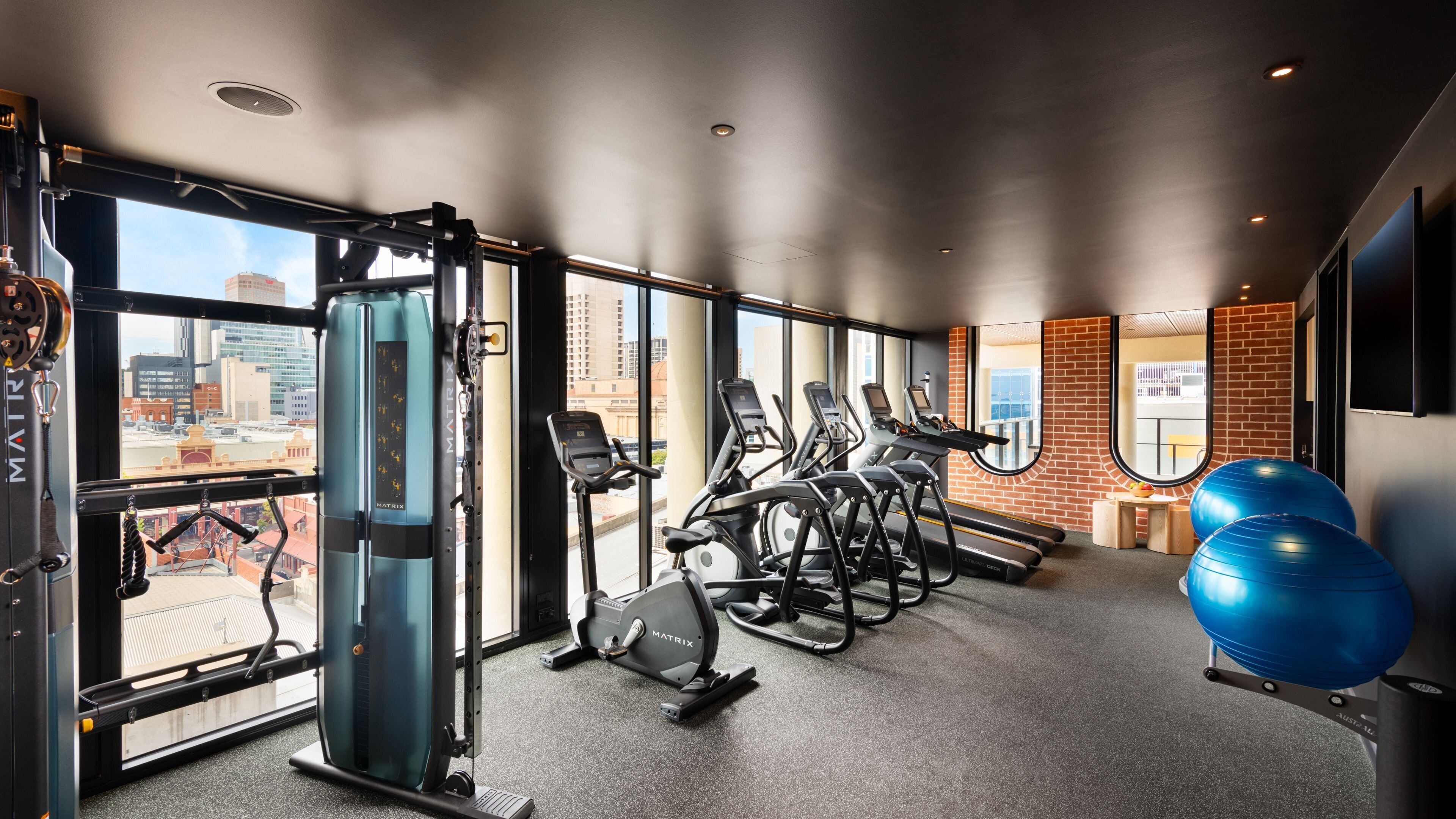 A gym with cardio equipment, weight machines, and exercise balls.