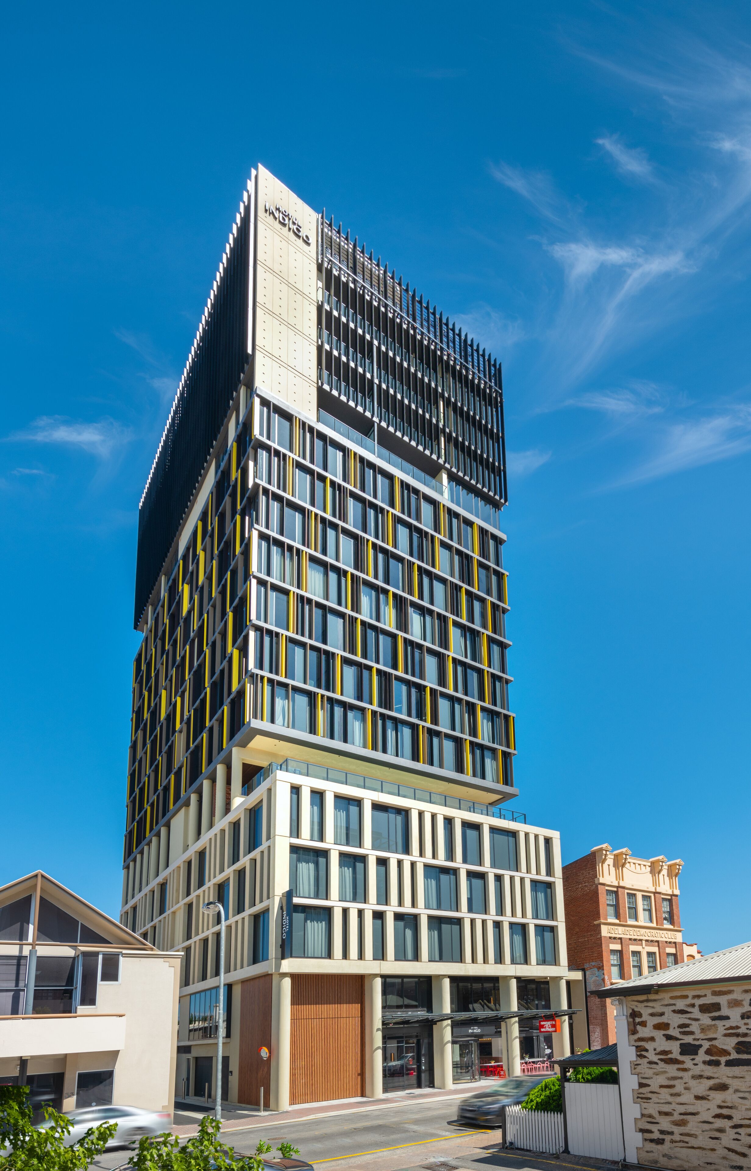 A modern hotel with a multi-story structure, large windows, and a prominent entrance.