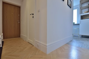 Enter a serene space with a door leading to a room featuring a tiled floor and a window offering a view of the outside.