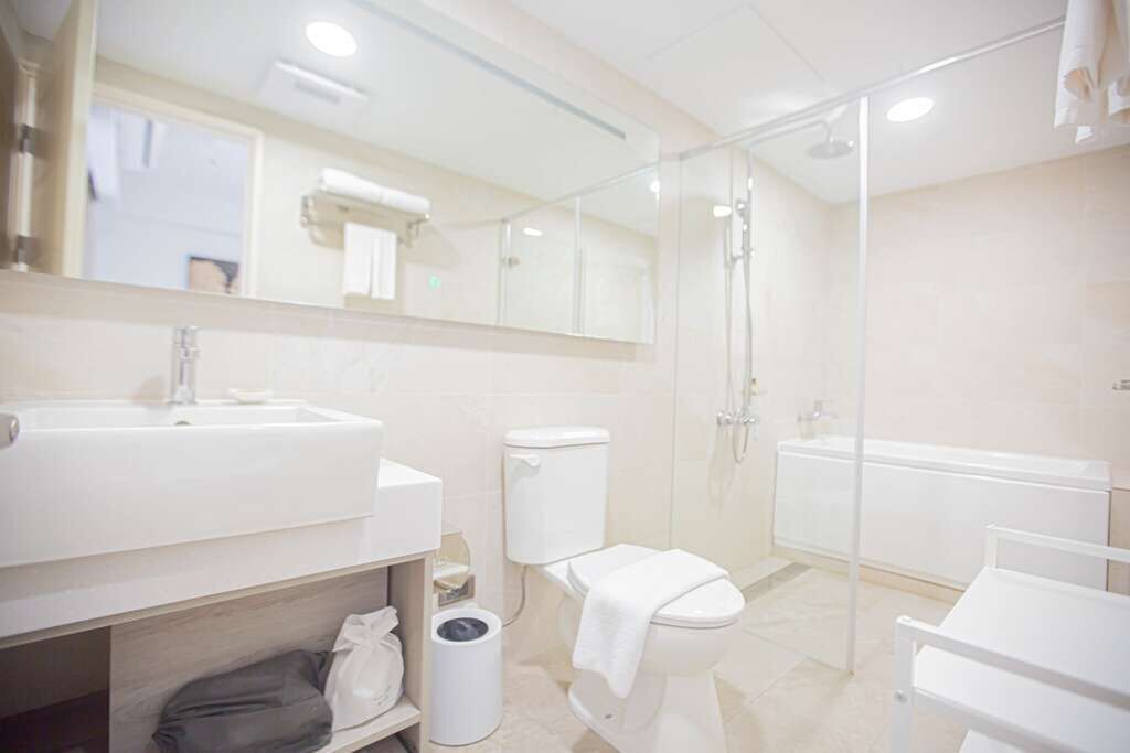 A modern bathroom with a sink, toilet, and shower area.