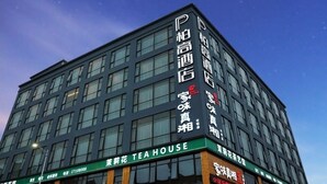 A modern building with multiple floors, featuring a prominent sign for a tea house on the ground level. - Paco Hotel (Shenzhen)
