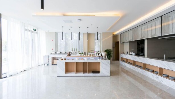 A modern hotel lobby with a central reception desk, a large flat-screen TV, and a marble counter. - Berkesy Residence (Shanghai)