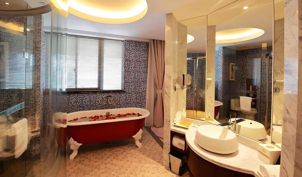 A modern bathroom with a freestanding bathtub, a large mirror, and a glass-enclosed shower area.